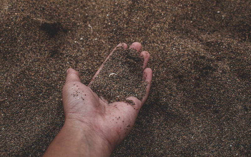 Hand holding a soil sample at a remediation site