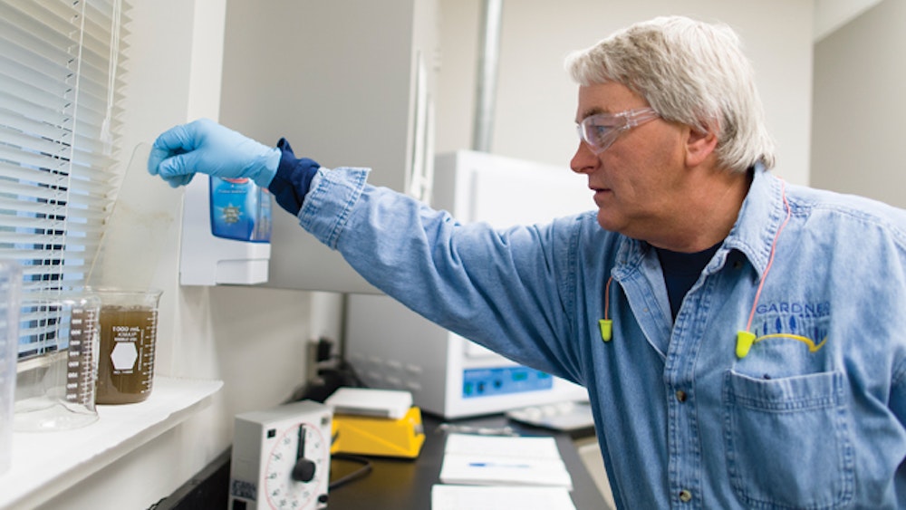 Man wearing gloves doing wastewater testing 